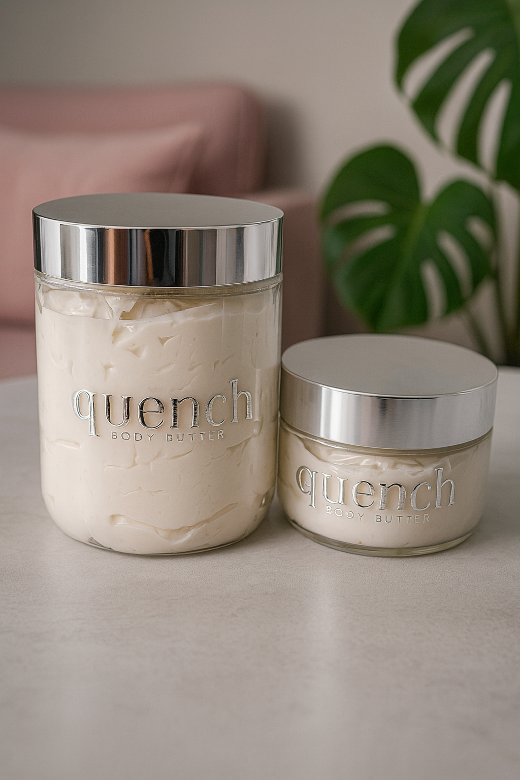 Two jars of 'quench' body butter on a surface with a plant in the background.